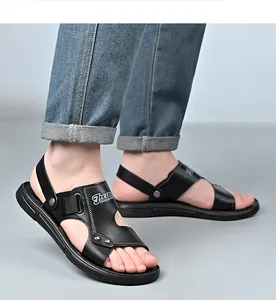 Close-up of men's casual black leather sandals with adjustable strap on a model's feet.
