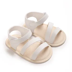 Ein Paar minimalistische weiße Baby-Sandalen mit weicher Sohle und Klettverschluss