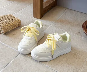 Close-up of children's white sports shoes with stylish yellow laces and non-slip sole