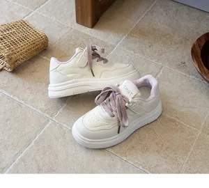 Detailed view of white children's sneakers with purple laces on stone tile floor