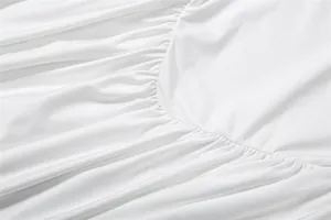 Nahaufnahme der weichen, weißen gerafften Stofftextur an einem stylischen, ärmellosen Kleid
