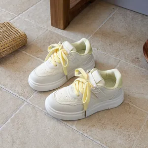 Stylish children's white sneakers featuring yellow laces and durable anti-slip rubber soles