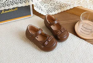 Détail de chaussures Mary Jane vintage en cuir marron pour filles avec nœud