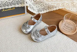 Gros plan de chaussures Mary Jane rétro françaises argentées pour filles avec nœud.