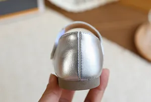 Détail du talon d'une chaussure argentée pour fille avec couture et semelle souple