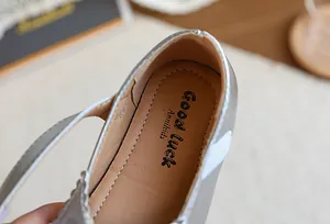 Gros plan sur la semelle intérieure et le logo des chaussures Mary Jane argentées pour fille