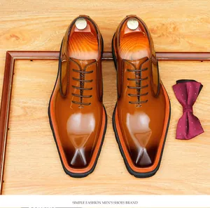 Vue détaillée de chaussures Oxford en cuir marron brillant avec des semelles orange