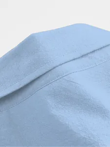 Close-up of light blue cotton linen shirt collar showing fine stitching and fabric texture
