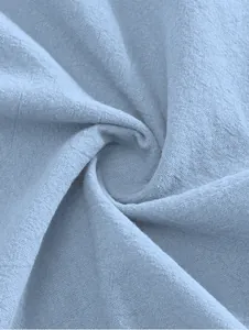 Close-up of light blue cotton linen fabric showing breathable weave texture