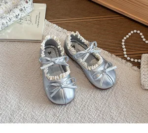 Glänzende silberne Mary Jane Schuhe für Mädchen mit Spitzenrüschen und Schleifen.