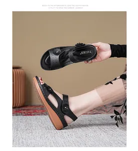 Detailed view of women's black wedge sandals featuring floral accents and comfortable straps.