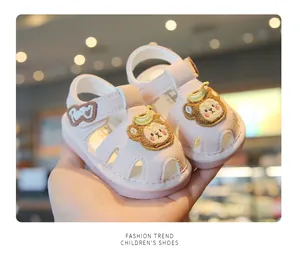 Close-up of pink baby walking sandals with cute cartoon bear patches and soft anti-slip soles