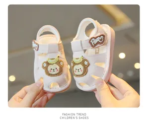 Close-up detail of pink toddler sandals featuring a cute cartoon bear patch and soft sole