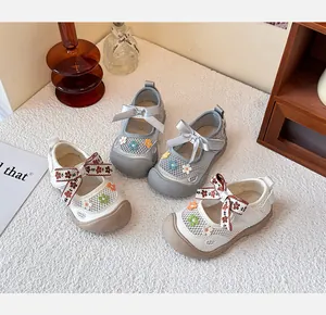 Detalle de zapatos de princesa de malla para niñas con bordados florales y lazos
