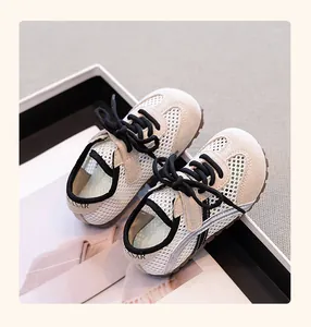 Close-up view of breathable mesh children's sneakers with black laces and suede detail.