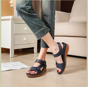 Dark blue wedge sandals for women with floral details shown on a model in a cozy room