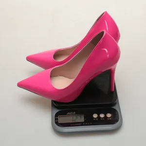 Detail showing weight of pink pointed-toe stiletto pump on a professional digital scale.