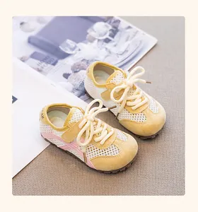 Close-up of yellow breathable mesh sneakers for girls with pink side stripes