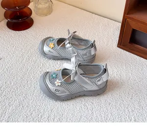 Vista detallada de zapatos de princesa para bebé en malla plateada con flores bordadas.
