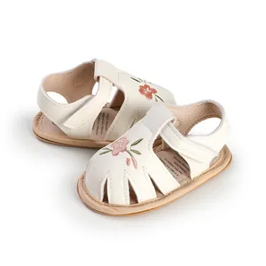 Close-up of baby girl walking sandals with delicate pink floral embroidery detail