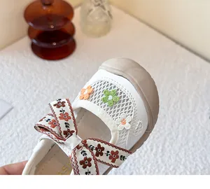 Primer plano de zapato de malla para niños con bordados florales y detalle de lazo