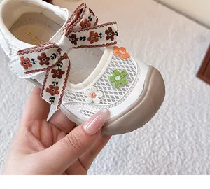 Vista detallada de zapatos de princesa para niñas de malla blanca con lazo de flores