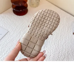 Detalle de suela de zapato para niños con diseño antideslizante y marca de talla 23.