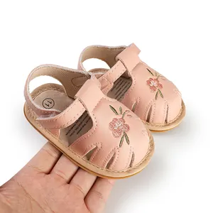Detailed view of pink leather baby girl sandals featuring delicate floral embroidery.