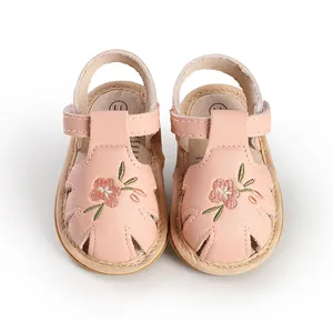 Front view of pink baby girl sandals featuring embroidered flowers and soft soles.