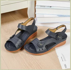 Close-up of navy blue wedge sandals featuring floral embellishments and magic tape closure.