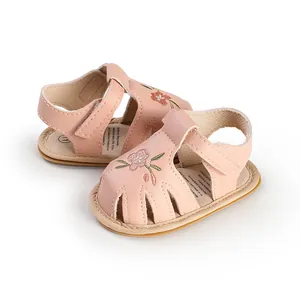 Detail view of pink embroidered baby sandals with soft soles and velcro straps.