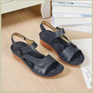 Detail view of navy blue wedge sandals for women with floral accents and Velcro strap.