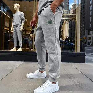 Vista detallada de pantalones deportivos grises texturizados para hombre con tejido único