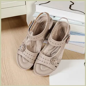 Detailed view of khaki platform sandals with floral accents and soft cushioned soles.