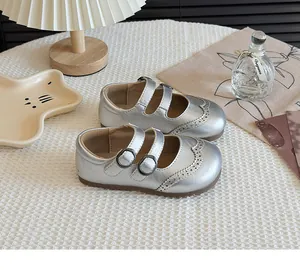 Detailed view of silver girls' Mary Jane shoes with brogue carving and double straps