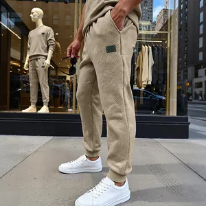 Detalle de pantalones de chándal beige texturizados para hombre con estilo urbano