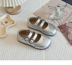 Close-up of silver girls princess shoes with double buckle straps and brogue details