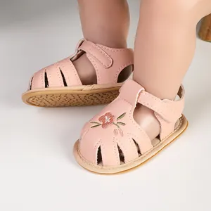 Detail view of pink baby girl sandals with flower embroidery and cut-out design.