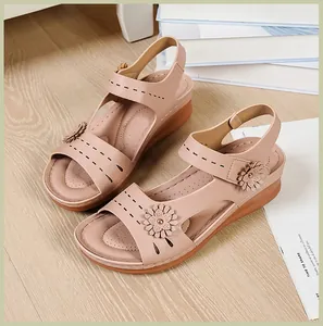 Close-up of comfortable pink wedge sandals with floral decoration and thick sole