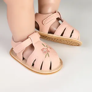 Detailed view of baby girl pink sandals with delicate flower embroidery and soft soles.