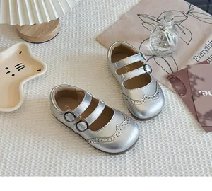 Detail view of silver Mary Jane leather shoes for girls with elegant brogue stitching.