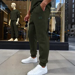 Detalle de pantalones de chándal texturizados para hombre en verde oliva con puños.