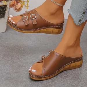 Side view of women's brown wedge slippers with buckle straps and white stitching