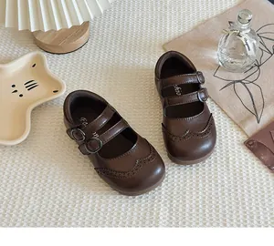 Detailed overhead view of brown children's Mary Jane shoes featuring wingtip brogue patterns.