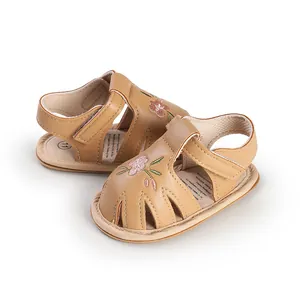 Close-up of baby girl summer sandals with soft floral embroidery and velcro straps