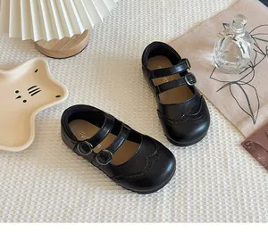 Detailed view of elegant girls' black leather Mary Jane shoes with brogue perforations