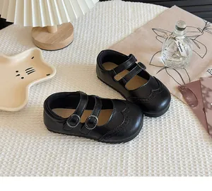 Close-up of black girl's Mary Jane leather shoes with double buckle straps and brogue detail