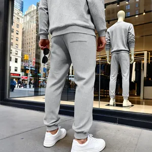 Vista trasera de pantalones deportivos grises con textura para hombre en entorno urbano
