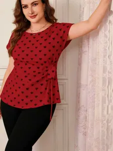 Woman wearing plus size red short sleeve blouse with black heart print and side tie