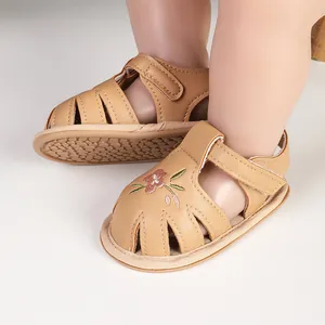 Close-up of khaki baby girl sandals with delicate flower embroidery and soft soles